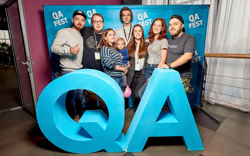 Учасники конференції біля об’ємних літер QA